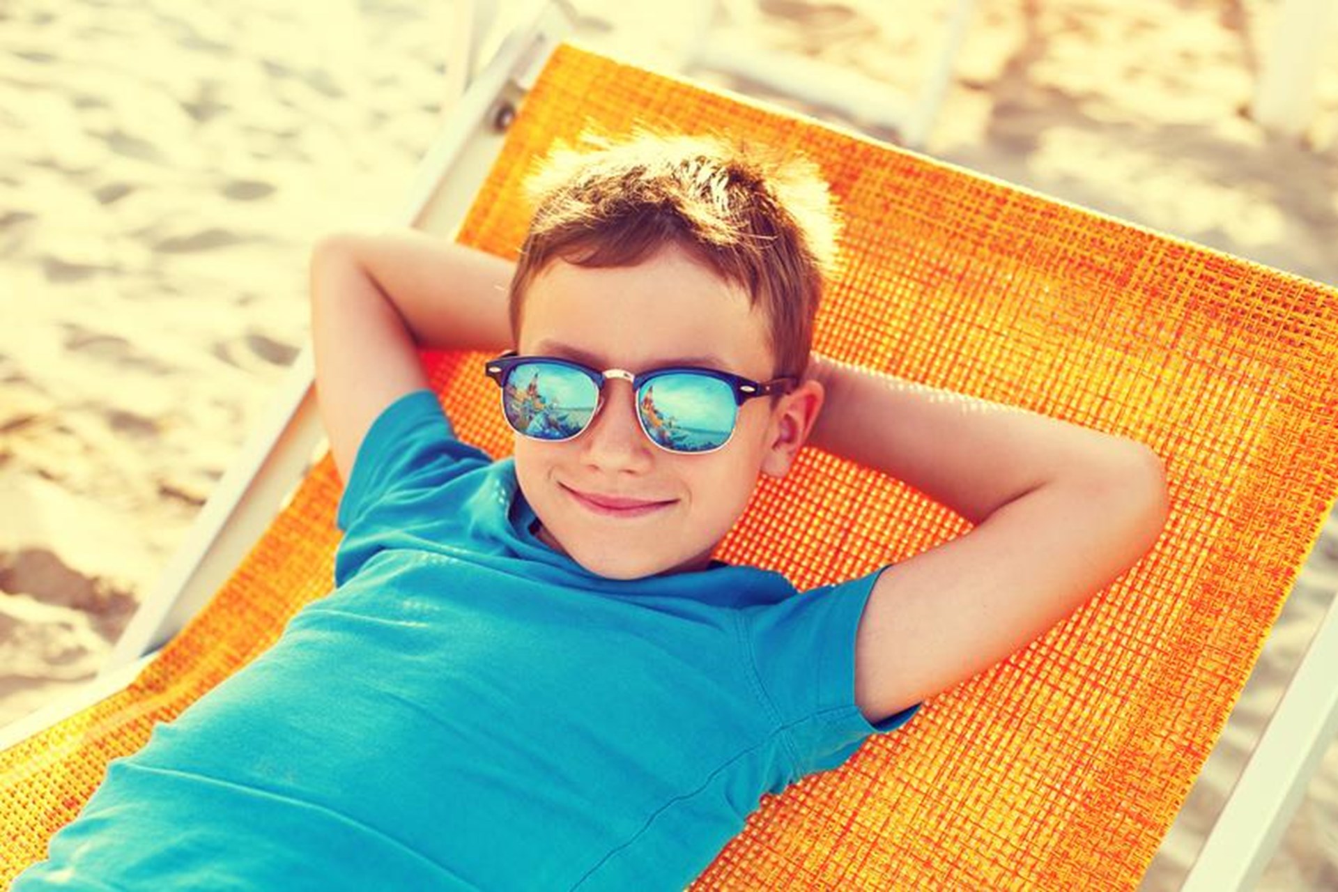 Junge im Liegestuhl im Sand