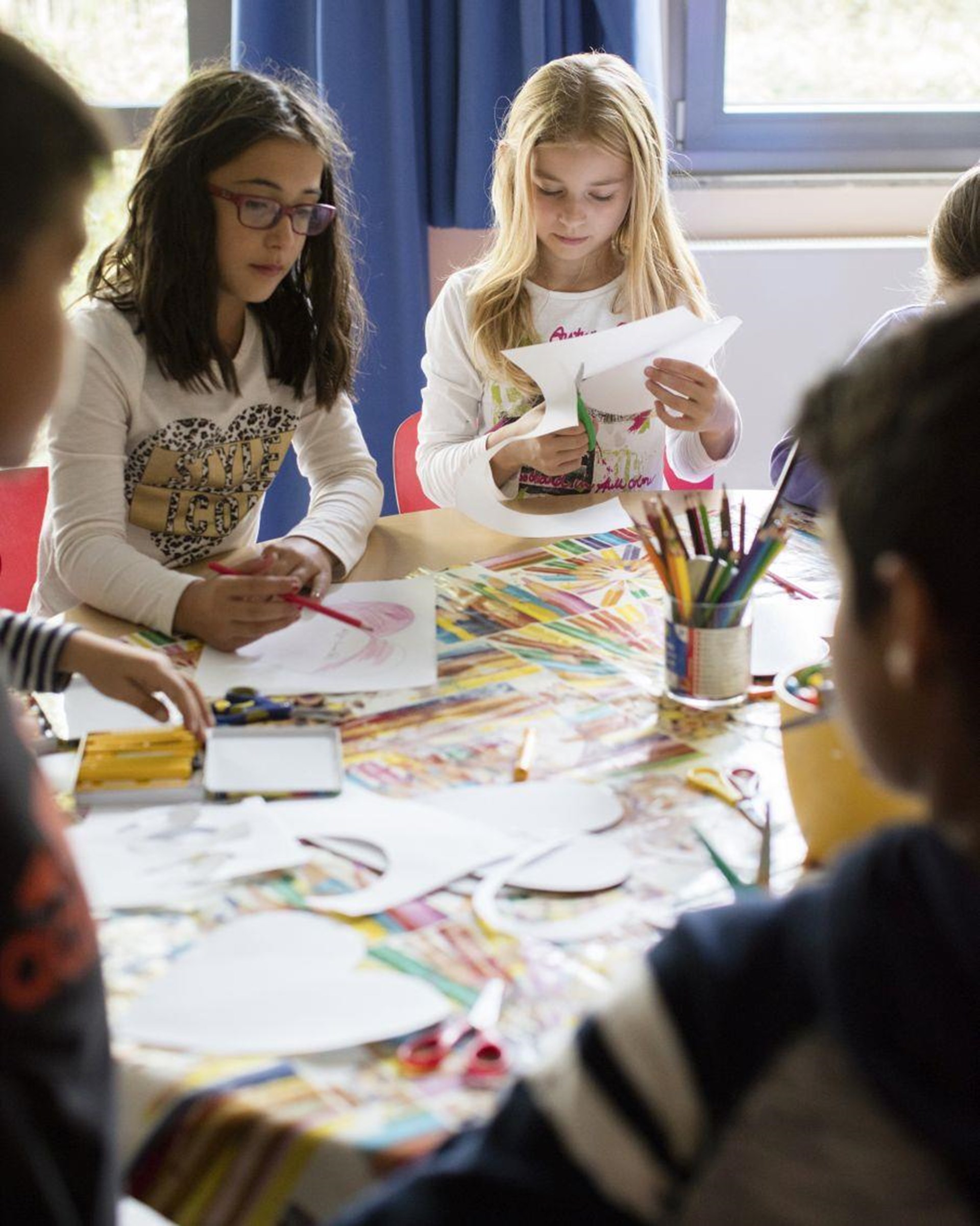 Schulkinder basteln an einem Tisch